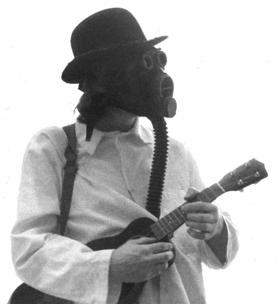 Hans Rickheit wearing a gas mask and playing a ukulele